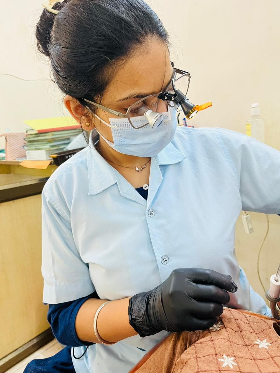 Dr. Bhavya Soni performing a procedure under magnification loupes